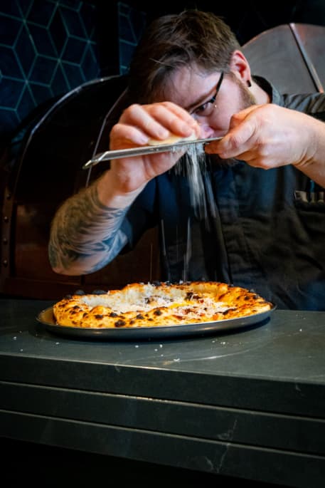 Chef finishing pizza at TRIBE Restaurant