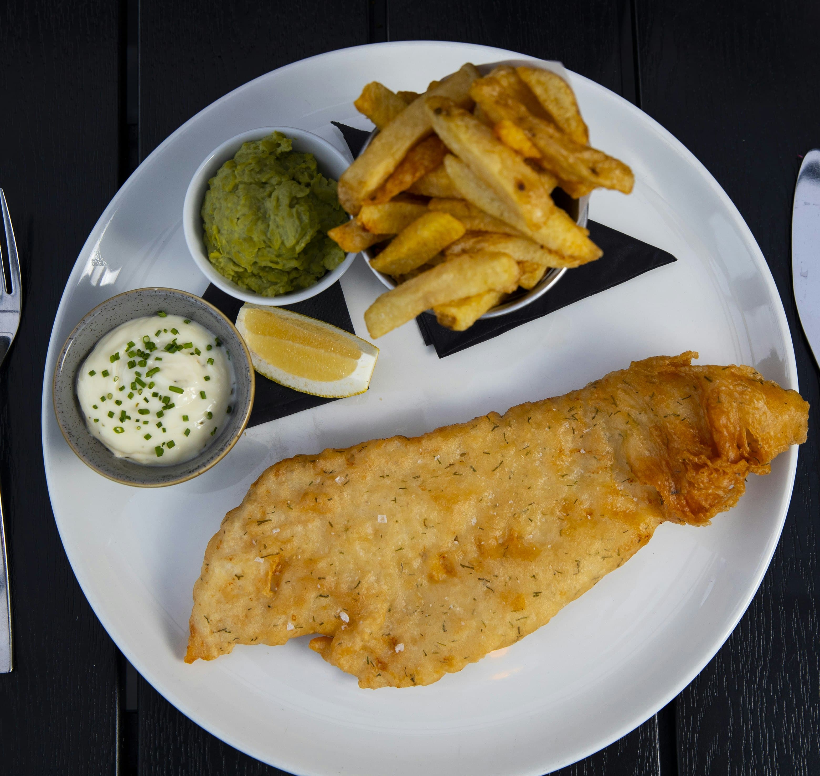 Signature fish and chips dish served with tartar sauce